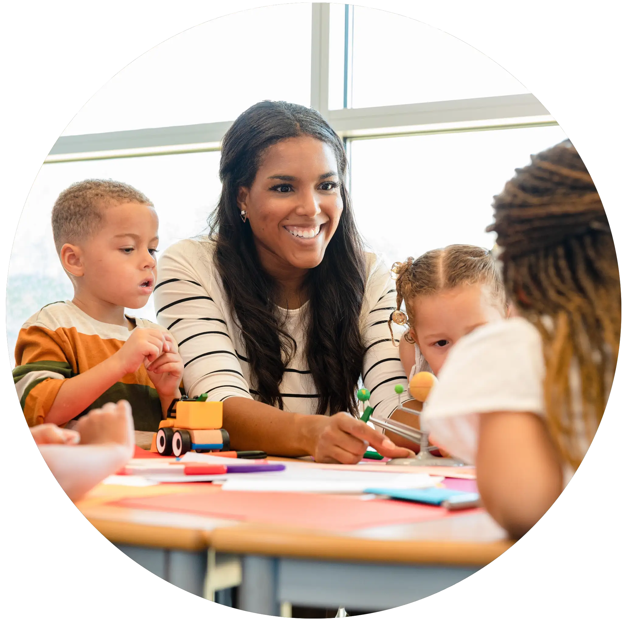 A school psychologist plays with young children in a classroom.