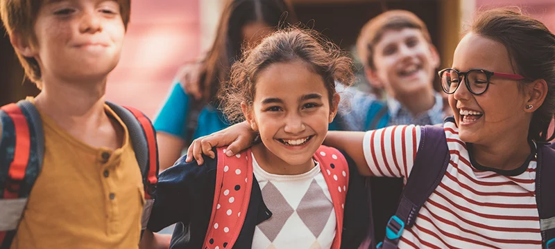 3 smiling kids at school