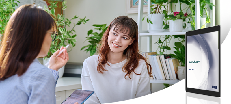 a female psychologist speaks with a smiling patient or fellow psychologist while a graphic image of the PAR white paper is in the foreground to represent the paper's topic
